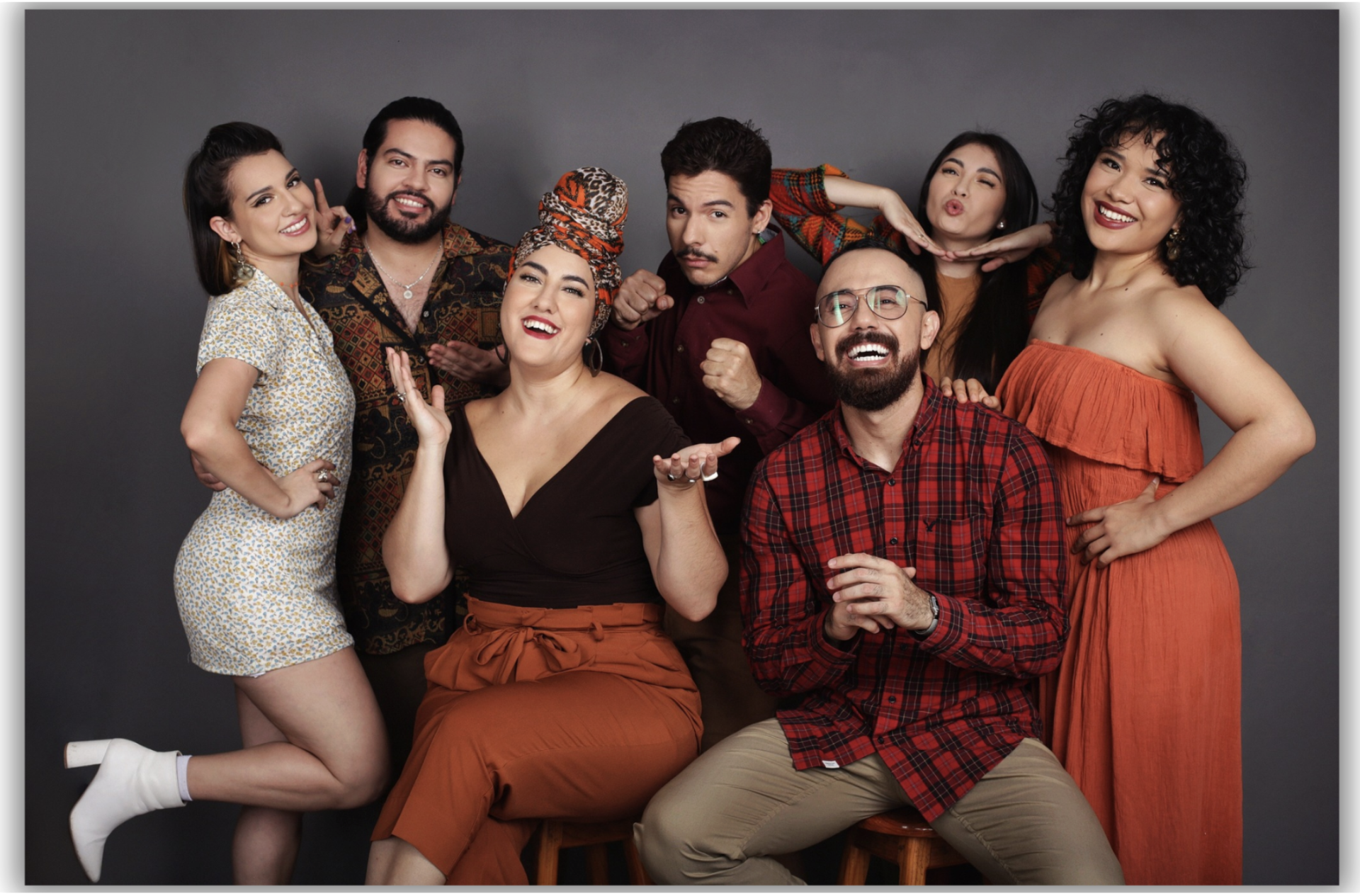 Vox A Cappella Band singers pose in orange, black and red for a group photo.